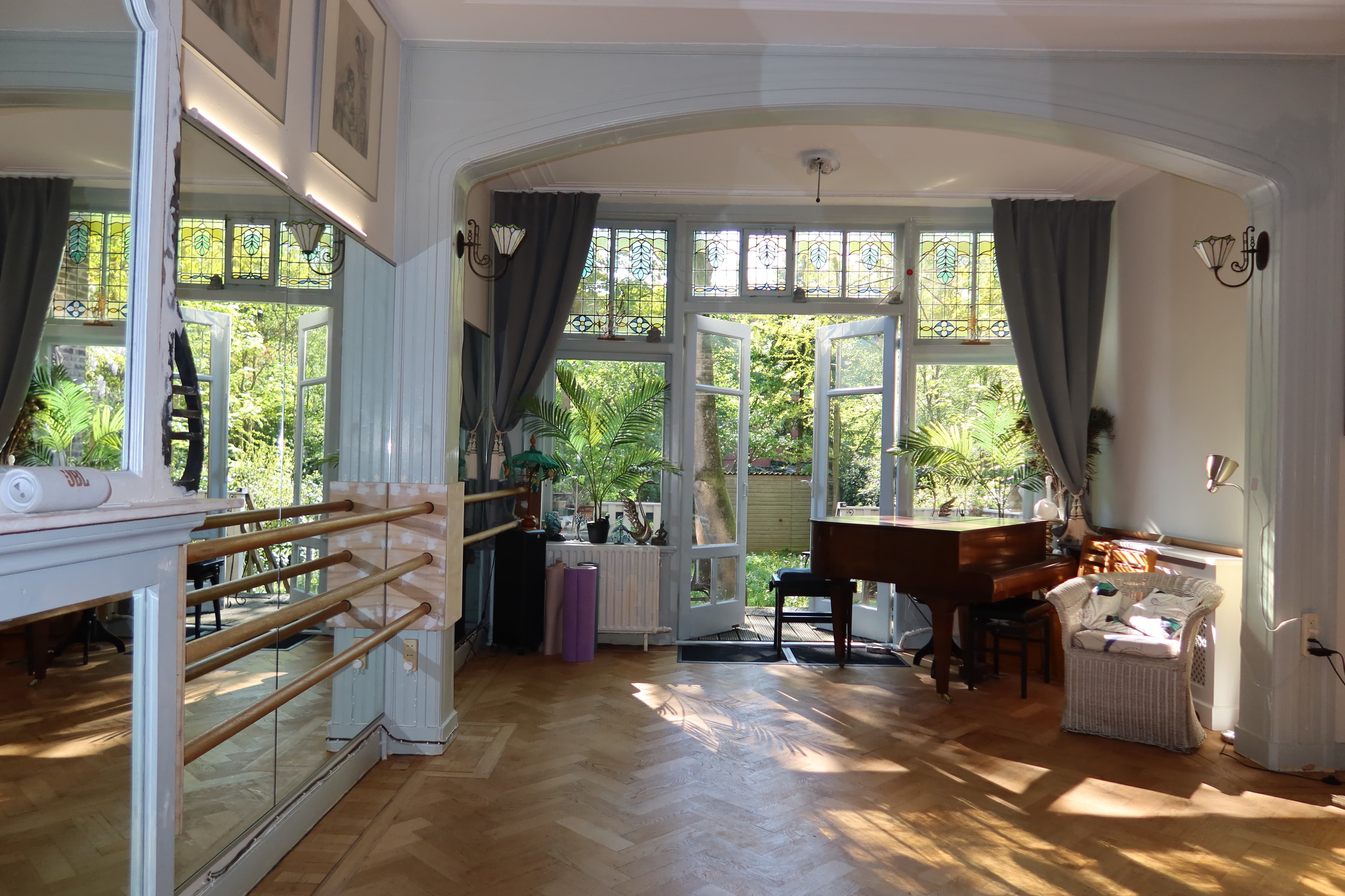 The Arabesque studio — sunlit room with ballet barre and grand piano
