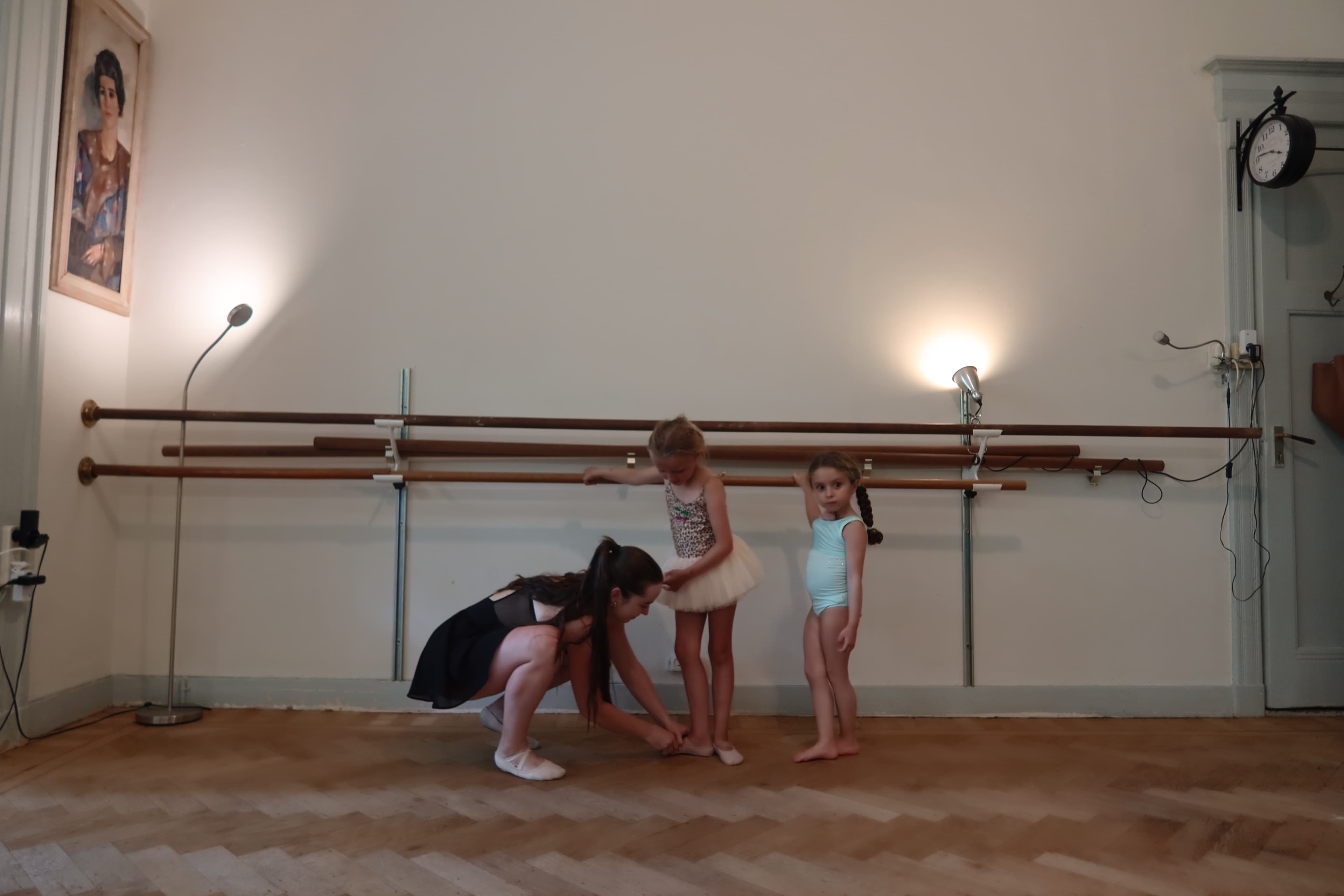 Studio founder teaching young ballet students at the barre