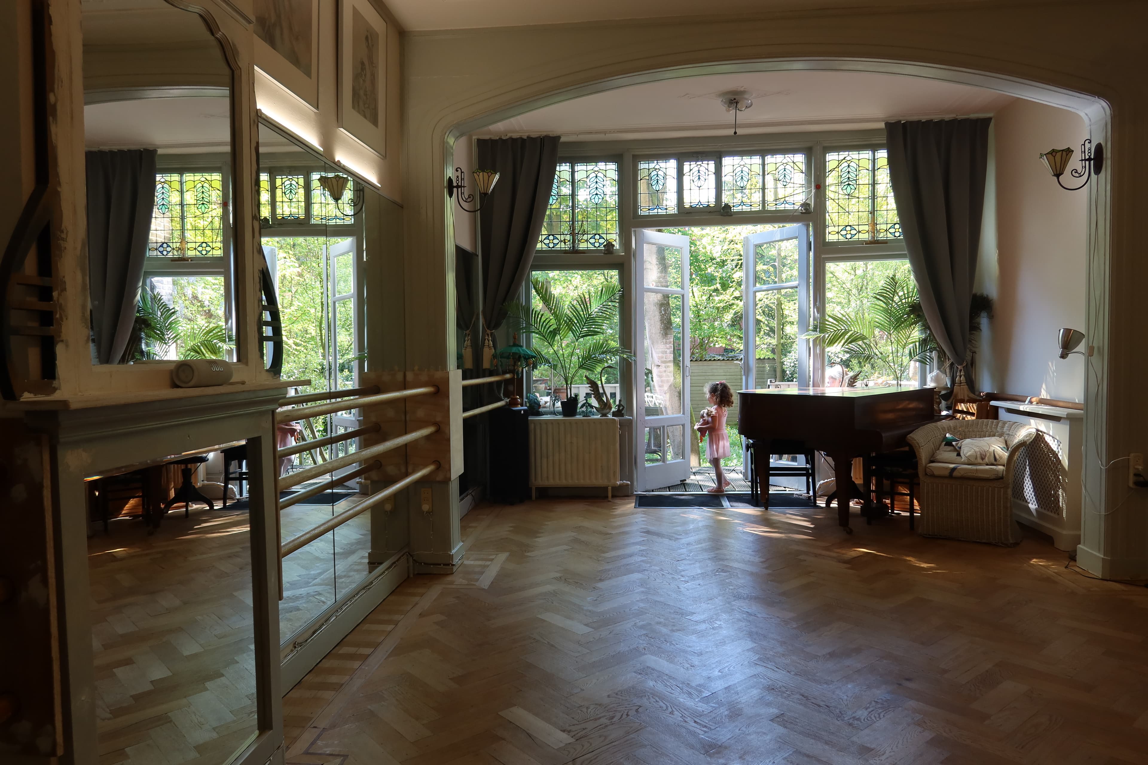 The Arabesque studio — sunlit room with ballet barre and grand piano